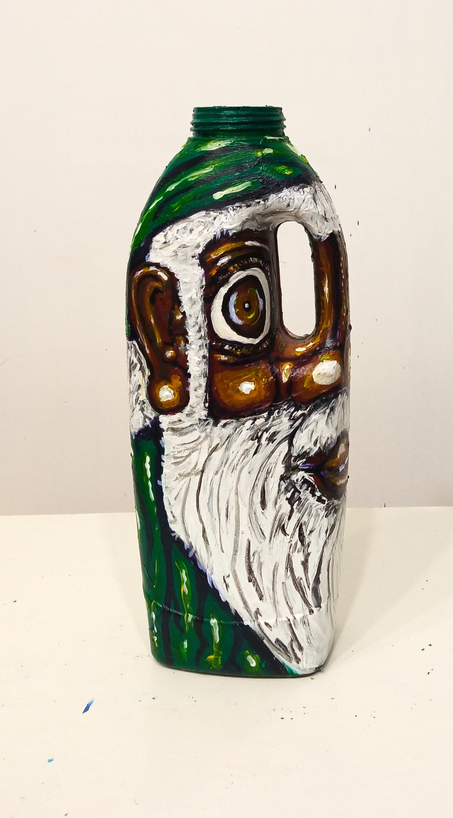 Black Santa Claus Wearing a Green Costume Created out of Recycled Plastic Bottle . [Recycled Art]. Ivan Fyodorovich.  Left side view