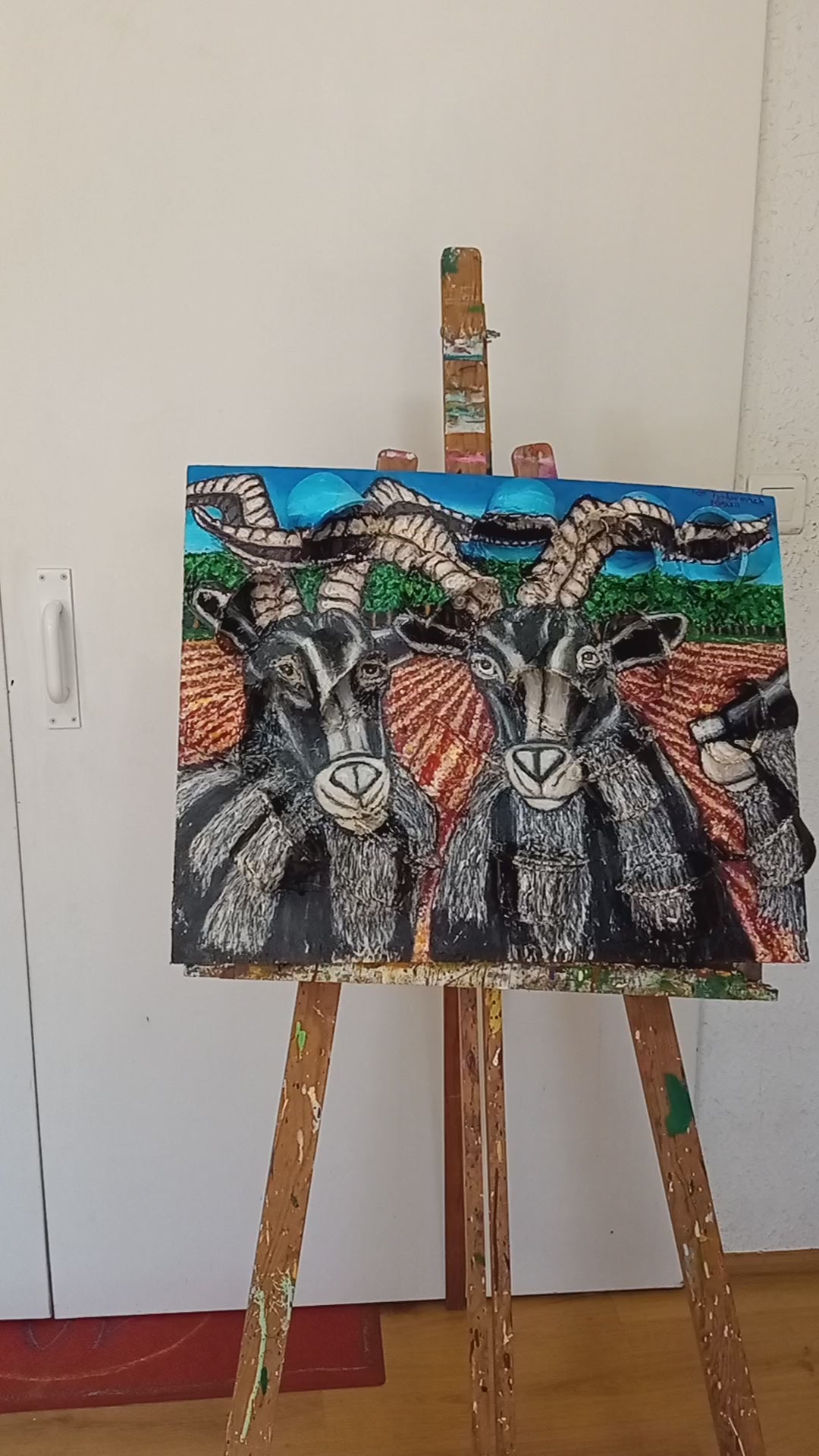 3D portrait of three male goats in a field with a pinetree forest in the background. Acrylic paint on woodboard and recycled plastic rice containers.[Recycled Art]. Video